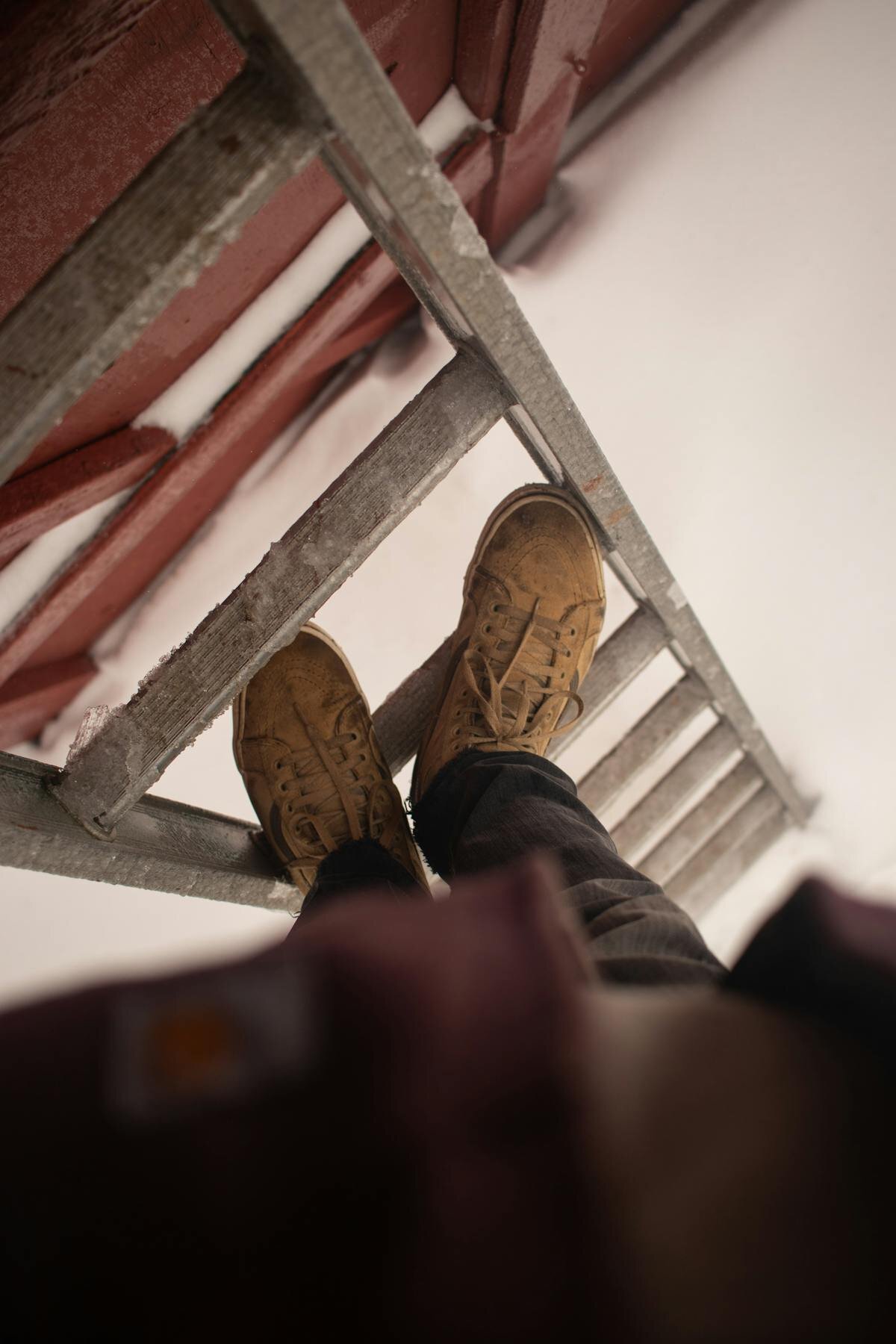 Properly set up extension ladder with stabilizer and standoff for pressure washing